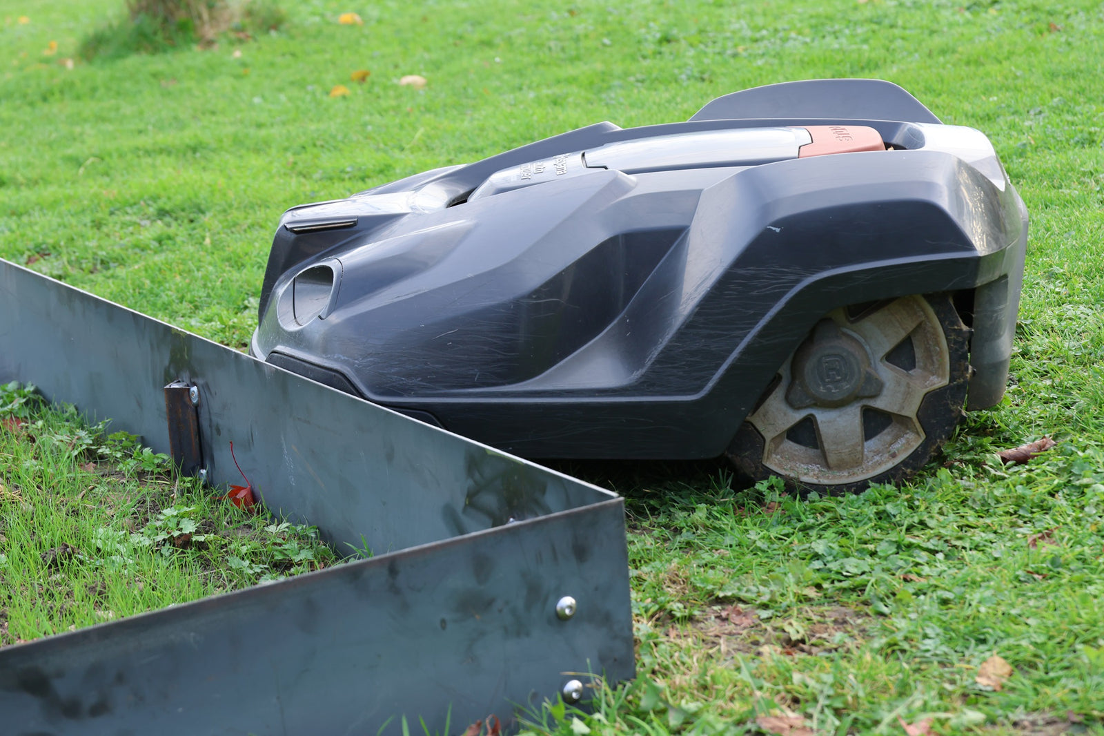 Stahlblech 150 mm x 2000 mm auf Rasen montiert mit Ecke, Rasenmäher fährt in Stahlblech