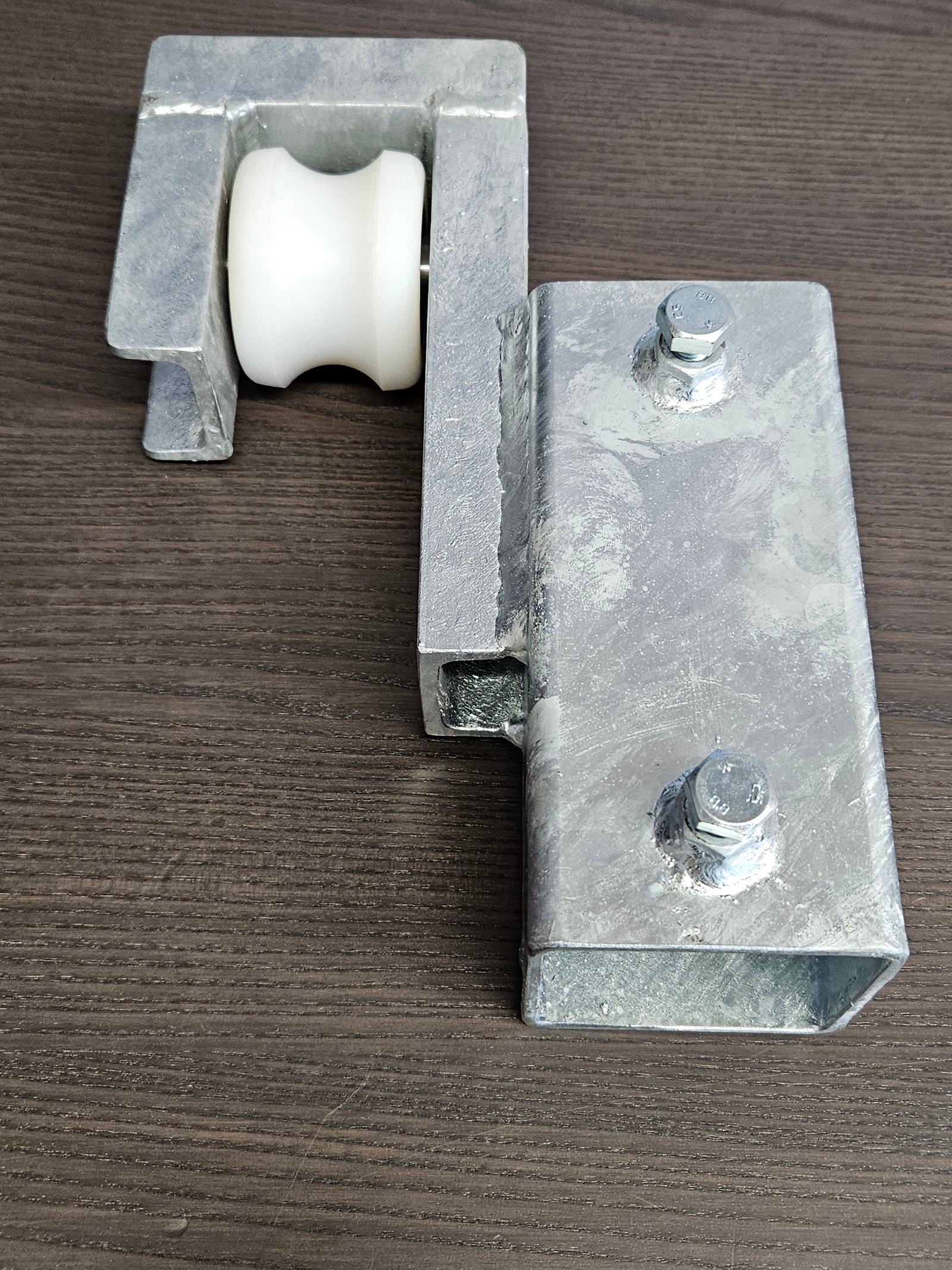 Schiebetorhalterung: Vierkantrohr 9x9 cm, 30 cm lang mit angeschweisster Halerung, in der Halterung mit Schraube befestigt ein Palettrolli Rad das leicht ausgefräst ist, damit ein Rohr darin geführt werden kann.